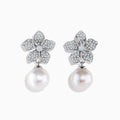 The 14K White Gold Diamond Flower and Fresh Water Pearl Drop Earrings feature diamond-studded flower tops with large round freshwater pearls dangling below, beautifully displayed against a white background.