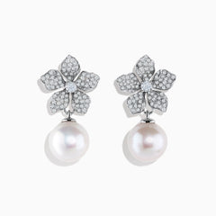 The 14K White Gold Diamond Flower and Fresh Water Pearl Drop Earrings feature diamond-studded flower tops with large round freshwater pearls dangling below, beautifully displayed against a white background.