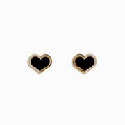 The Eclipse 14K Yellow Gold Onyx and Diamond Heart Earrings feature heart-shaped studs with black onyx centers and a border of sparkling diamonds, displayed on a plain white background.