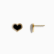 The Eclipse 14K Yellow Gold Onyx and Diamond Heart Earrings feature heart-shaped studs with black onyx centers and a border of sparkling diamonds, displayed on a plain white background.