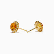 The 14K Yellow Gold Citrine and Diamond Halo Stud Earrings feature round orange citrine centers encircled by a halo of sparkling diamonds, all set in yellow gold.