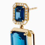 14K Yellow Gold Emerald-Cut Blue Topaz and Diamond Drop Earrings feature large rectangular blue topaz stones topped with smaller gems, both outlined by sparkling clear diamonds, displayed on a white background.