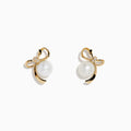 14K Yellow Gold Diamond Fresh Water Pearl Earrings feature ribbon-shaped designs, each adorned with a freshwater pearl and a small diamond at the top, displayed against a plain white background.
