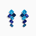 The 14K White Gold Blue Topaz and Iolite Earrings feature square and rectangular blue gemstones arranged diagonally, creating a striking and elegant accessory.