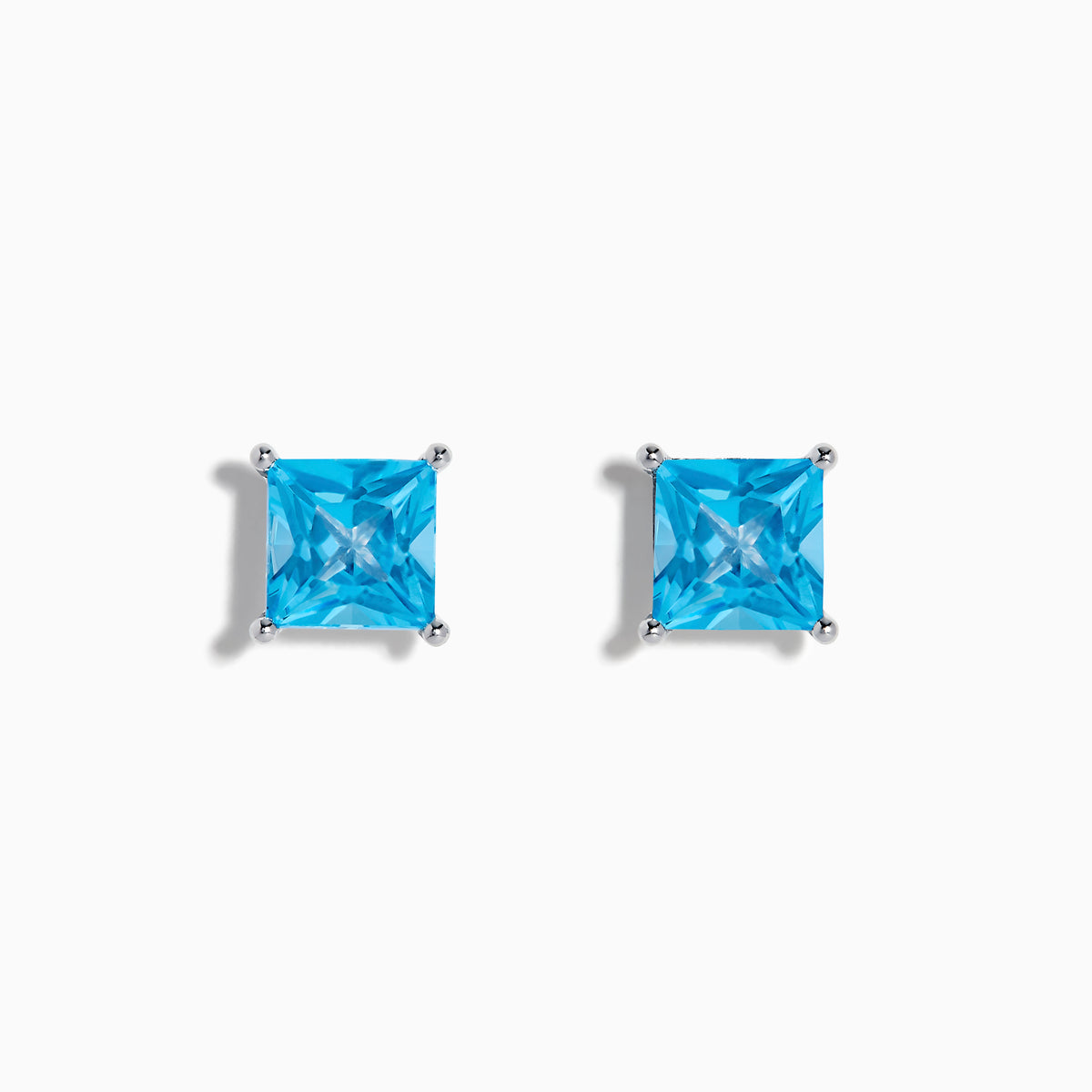 The Ocean Bleu 14K White Gold Blue Topaz Stud Earrings feature square-cut blue topaz in four-prong settings, displayed on a white background.