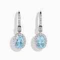 14K White Gold Aquamarine and Diamond Dangle Earrings feature oval aquamarines encircled by sparkling diamonds, with additional diamonds on the hooks—an elegant choice for any occasion.