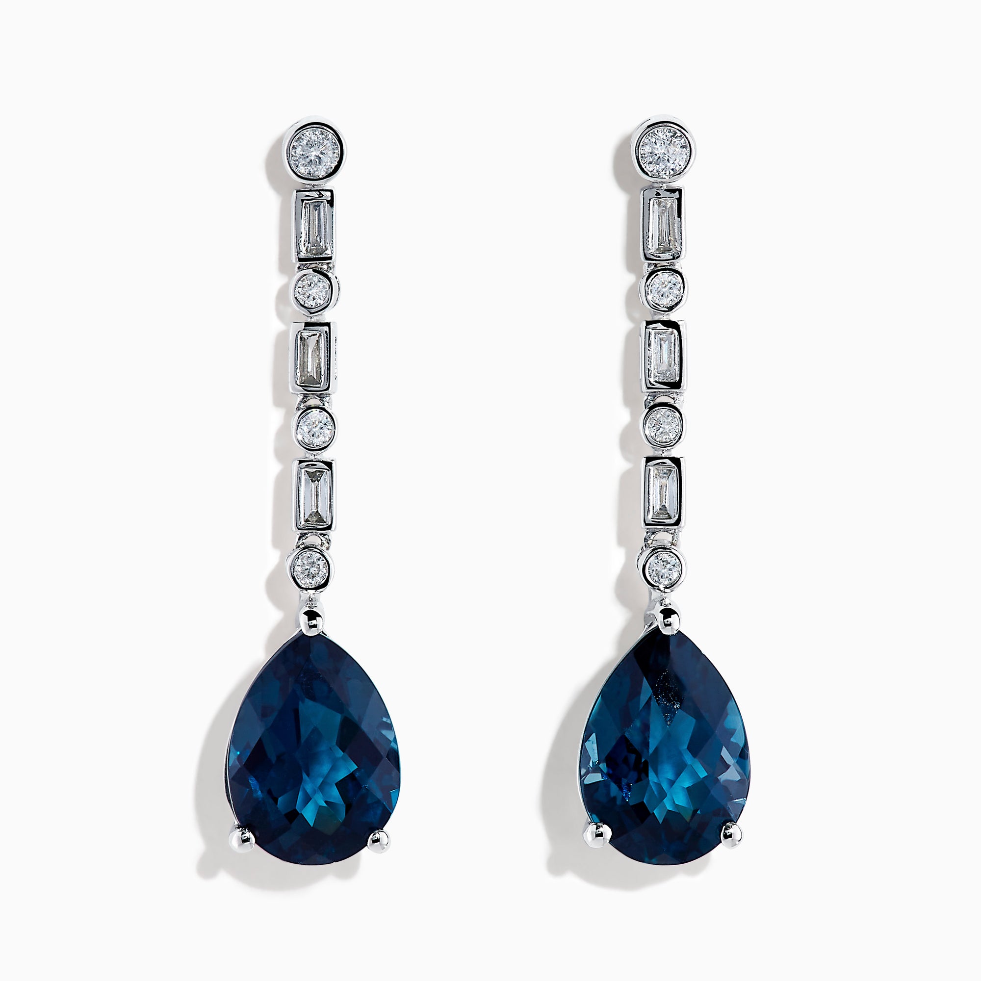 The 14K White Gold Blue Topaz and Diamond Linear Drop Earrings feature large teardrop-shaped blue topaz gems with a vertical row of round and rectangular diamonds set above each stone.