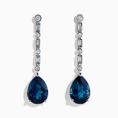 The 14K White Gold Blue Topaz and Diamond Linear Drop Earrings feature large teardrop-shaped blue topaz gems with a vertical row of round and rectangular diamonds set above each stone.