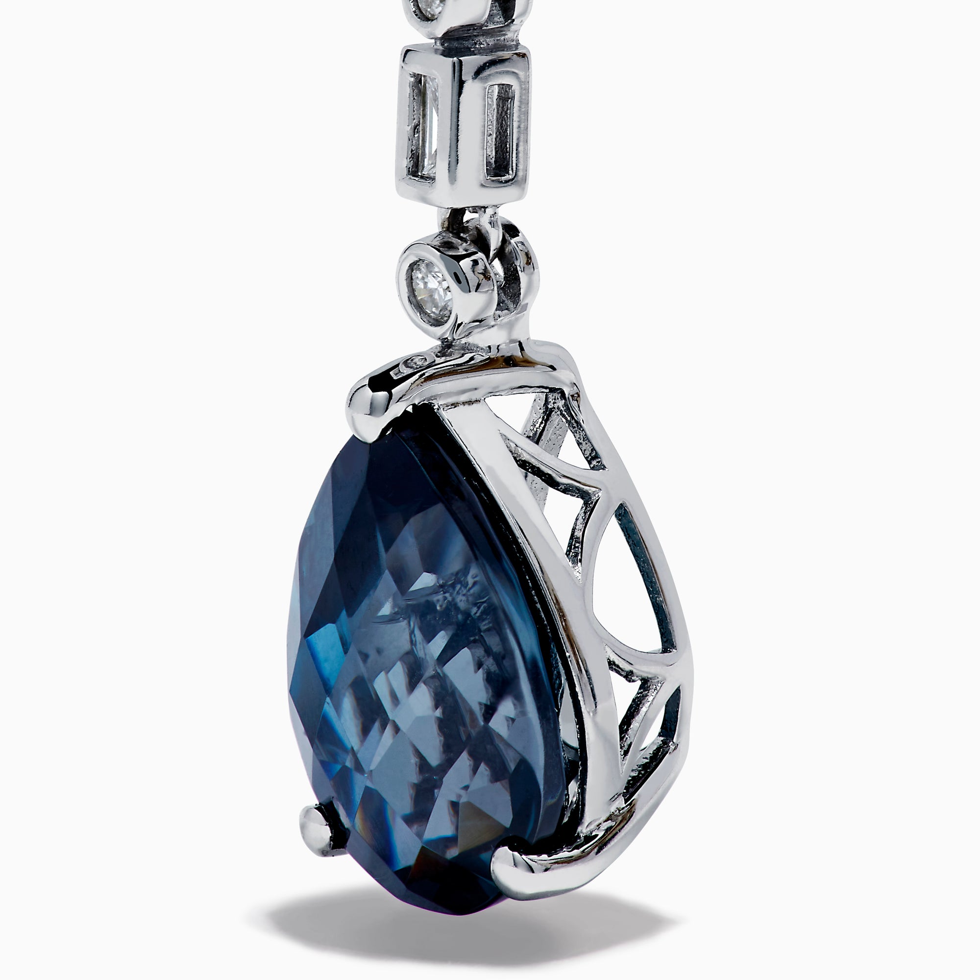 The 14K White Gold Blue Topaz and Diamond Linear Drop Earrings feature large teardrop-shaped blue topaz gems with a vertical row of round and rectangular diamonds set above each stone.