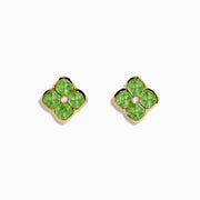 The 14K Yellow Gold Peridot and Diamond Earrings are four-petal flower studs featuring peridot gemstones on each petal with a central diamond, displayed against a white background.