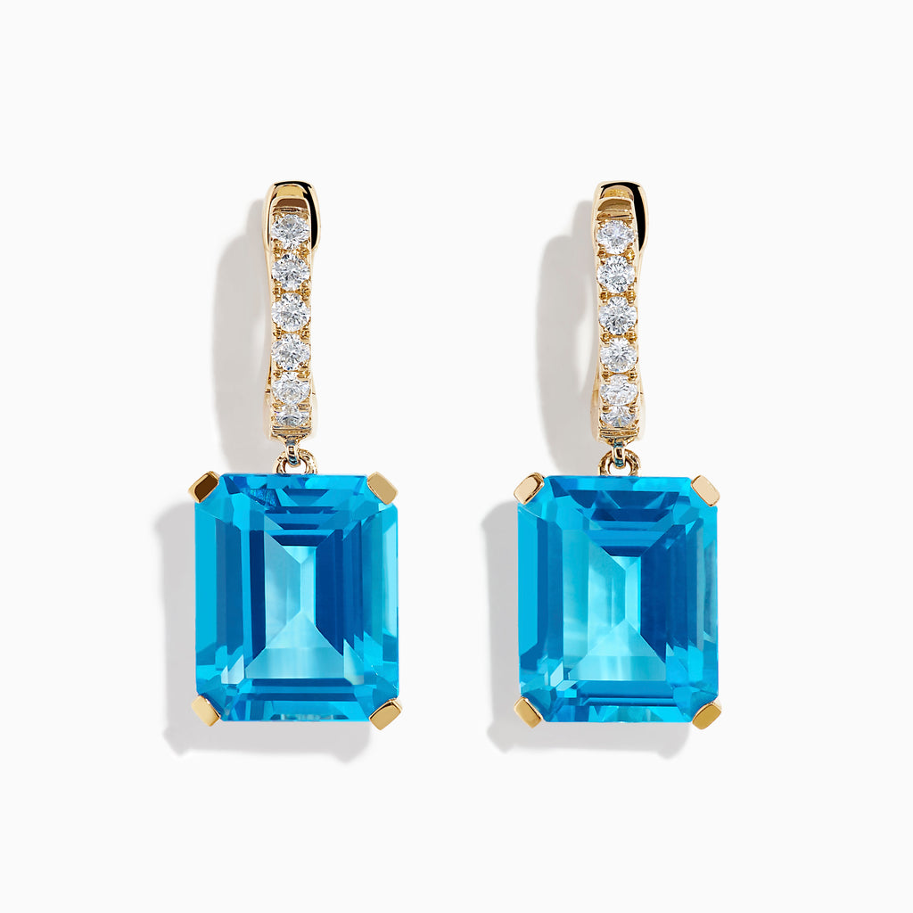 The 14K Yellow Gold Blue Topaz and Diamond Dangle Earrings feature large emerald-cut blue topaz gemstones and small round diamonds, displayed elegantly on a white background.