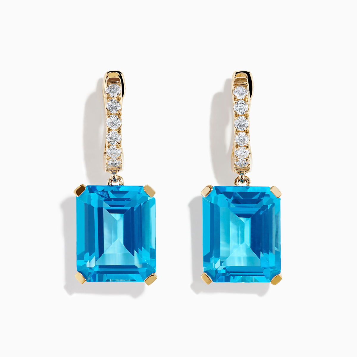 The 14K Yellow Gold Blue Topaz and Diamond Dangle Earrings feature large emerald-cut blue topaz gemstones and small round diamonds, displayed elegantly on a white background.