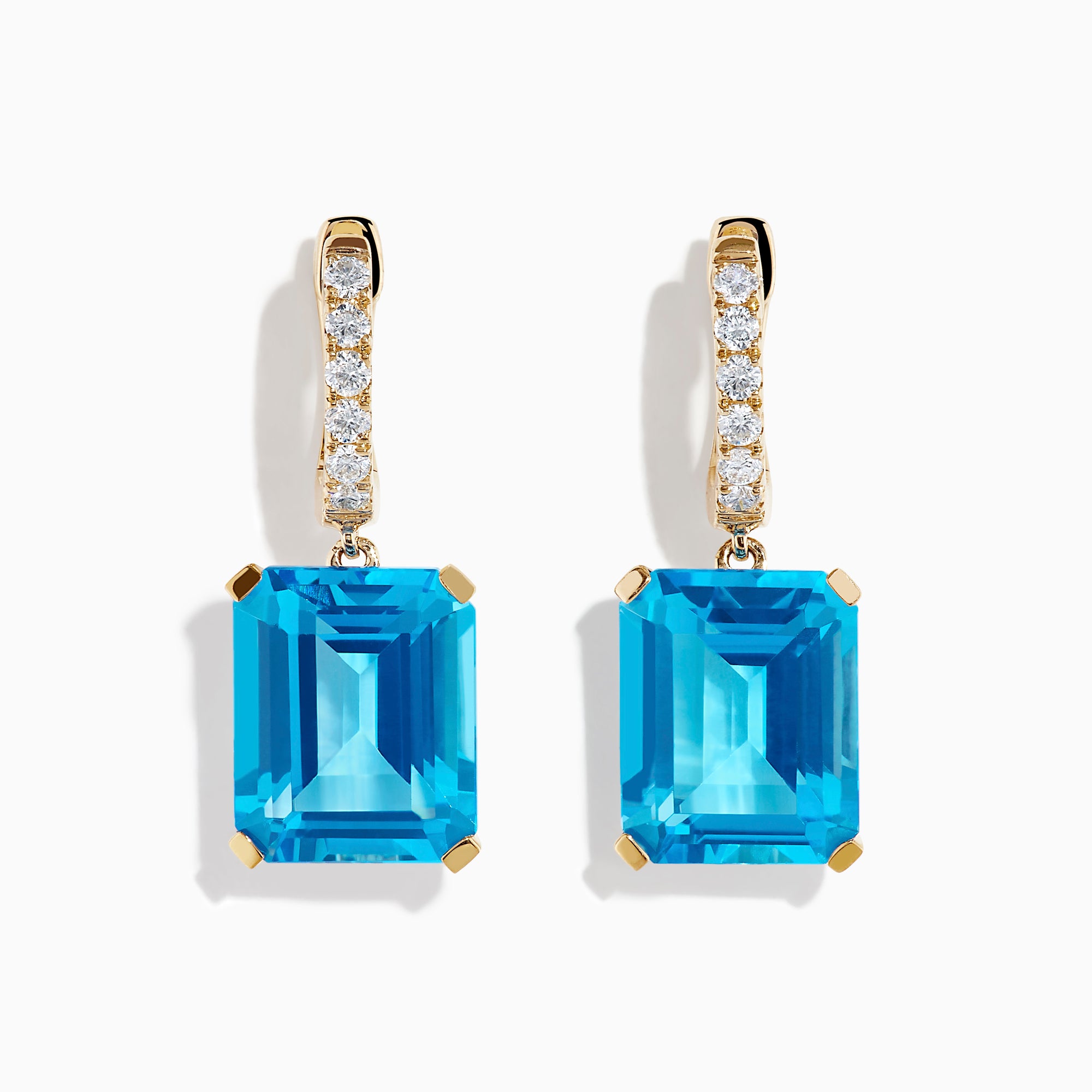 The 14K Yellow Gold Blue Topaz and Diamond Dangle Earrings feature large emerald-cut blue topaz gemstones and small round diamonds, displayed elegantly on a white background.