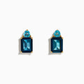 A pair of 14K Yellow Gold Sky Blue and London Blue Topaz Stud Earrings, featuring rectangular dark blue stones and teardrop-shaped light blue accents, shown on a white background.