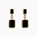 The Eclipse 14K Yellow Gold Onyx and Diamond Bezel Drop Earrings feature black rectangular onyx stones at the top and bottom, separated by a small clear diamond in the center.