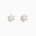 These 14K yellow gold earrings showcase a central freshwater pearl encircled by six sparkling diamonds arranged in a radiant pattern.
