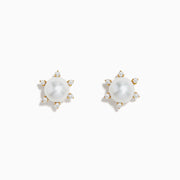 These 14K yellow gold earrings showcase a central freshwater pearl encircled by six sparkling diamonds arranged in a radiant pattern.