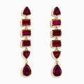 The 14K Yellow Gold Rhodolite Garnet Linear Drop Earrings feature five rhodolite garnets each in teardrop, triangle, and rectangle shapes, arranged vertically. Shown on a white background.