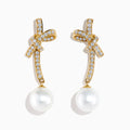 14K Yellow Gold Diamond Bow and Cultured Pearl Linear Drop Earrings, featuring diamond-studded bows and dangling cultured pearls, shown on a white background.