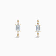 Lab Grown Diamond Emerald-Cut Huggie Earrings in 14K Yellow Gold, each with a central rectangular lab diamond and small round diamonds on the hoop, shown on a white background.