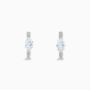A pair of Lab Grown Diamond Marquise Huggie Earrings in 14K white gold, featuring dazzling lab-created gemstones, elegantly displayed on a plain white background.
