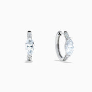 A pair of Lab Grown Diamond Marquise Huggie Earrings in 14K white gold, featuring dazzling lab-created gemstones, elegantly displayed on a plain white background.