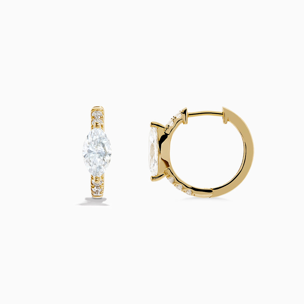 Lab Grown Diamond Marquise Huggie Earrings in 14K Yellow Gold, each showcasing a central round diamond and smaller accent diamonds along the vertical sides, displayed on a plain white background.