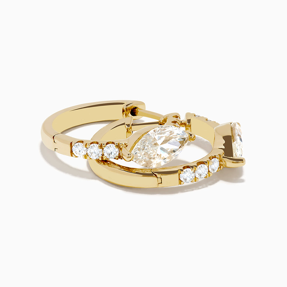 Lab Grown Diamond Marquise Huggie Earrings in 14K Yellow Gold, each showcasing a central round diamond and smaller accent diamonds along the vertical sides, displayed on a plain white background.