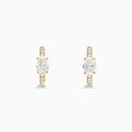Lab Grown Diamond Oval Huggie Earrings in 14K Yellow Gold, each with a central oval lab diamond and smaller round lab diamonds on the front, are shown against a plain white background.
