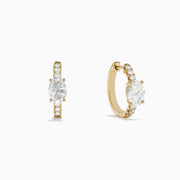Lab Grown Diamond Oval Huggie Earrings in 14K Yellow Gold, each with a central oval lab diamond and smaller round lab diamonds on the front, are shown against a plain white background.