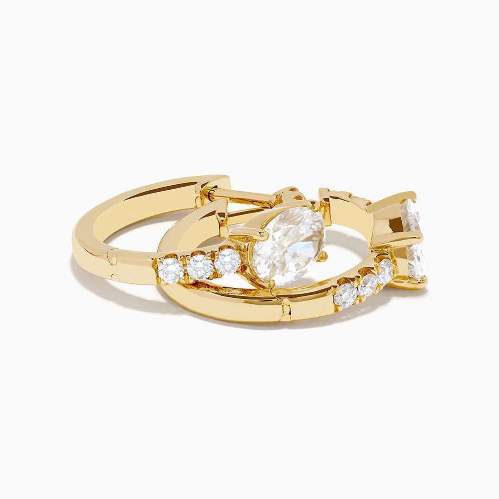 Lab Grown Diamond Oval Huggie Earrings in 14K Yellow Gold, each with a central oval lab diamond and smaller round lab diamonds on the front, are shown against a plain white background.