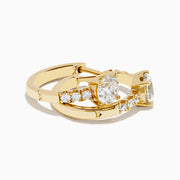 The Lab Grown Diamond Round Huggie Earrings in 14K Yellow Gold feature a central round lab diamond accented by a row of smaller lab diamonds, all set in sleek yellow gold and displayed on a white background.