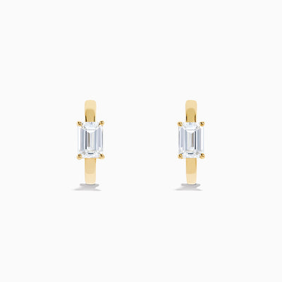 A pair of Lab Grown Diamond Emerald-Cut Huggie Earrings in 14K Yellow Gold is shown on a plain white background, each earring featuring a vertically set emerald-cut lab grown diamond at the center.