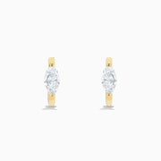 A pair of Lab Grown Diamond Marquise Huggie Earrings in 14K yellow gold, each with sparkling diamonds, shown against a plain white background.