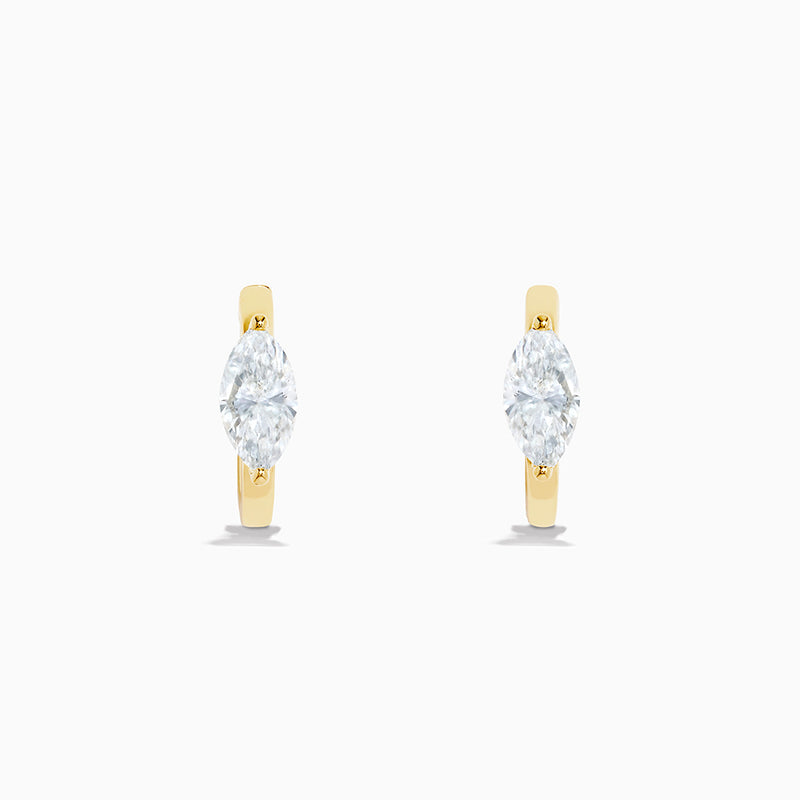 A pair of Lab Grown Diamond Marquise Huggie Earrings in 14K yellow gold, each with sparkling diamonds, shown against a plain white background.