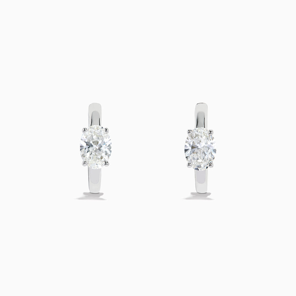 A pair of Lab Grown Diamond Oval Huggie Earrings in 14K white gold, each adorned with sparkling diamonds in a sleek, modern setting, displayed on a plain white background.