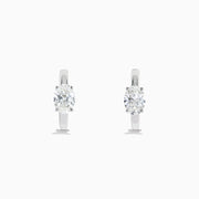 A pair of Lab Grown Diamond Oval Huggie Earrings in 14K white gold, each adorned with sparkling diamonds in a sleek, modern setting, displayed on a plain white background.