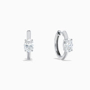 A pair of Lab Grown Diamond Oval Huggie Earrings in 14K white gold, each adorned with sparkling diamonds in a sleek, modern setting, displayed on a plain white background.
