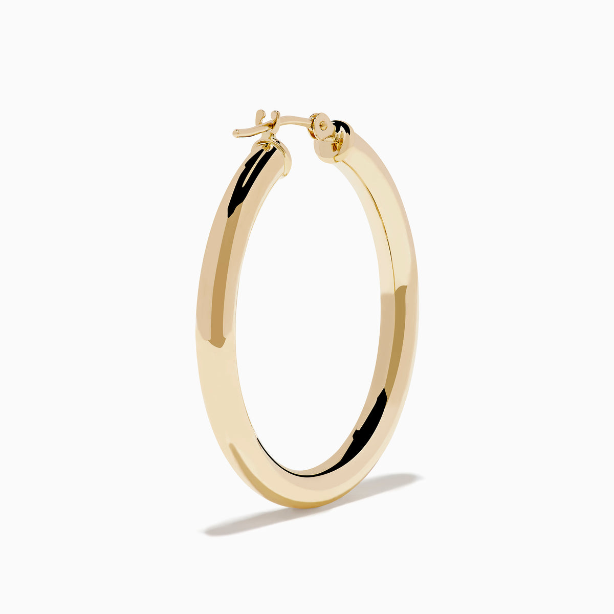 The 14K Yellow Gold Hollow Tube Hoops are sleek, polished earrings shown side by side against a white background, featuring classic yellow gold in a timeless hoop design with clasps at the top.