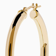The 14K Yellow Gold Hollow Tube Hoops are sleek, polished earrings shown side by side against a white background, featuring classic yellow gold in a timeless hoop design with clasps at the top.