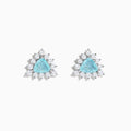 A pair of 18K white gold GIA certified Paraiba and diamond stud earrings with triangular blue gems surrounded by a halo of small diamonds, set in silver, displayed on a white background.