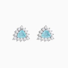 A pair of 18K white gold GIA certified Paraiba and diamond stud earrings with triangular blue gems surrounded by a halo of small diamonds, set in silver, displayed on a white background.