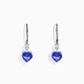 The Nahla Siri 14K White Gold Tanzanite and Diamond Leverback Earrings feature heart-shaped blue tanzanite stones accented with sparkling diamonds, shown on a white background.