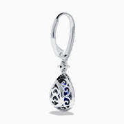 The Nahla 14K White Gold Tanzanite and Diamond Dangle Halo Earrings feature teardrop-shaped tanzanite stones surrounded by sparkling diamonds, set in elegant white gold and displayed against a white background.