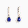 The Nahla 14K Yellow Gold Tanzanite and Diamond Dangle Halo Earrings showcase teardrop tanzanites encircled by diamonds, with extra diamonds on the hooks, all set against a white background.