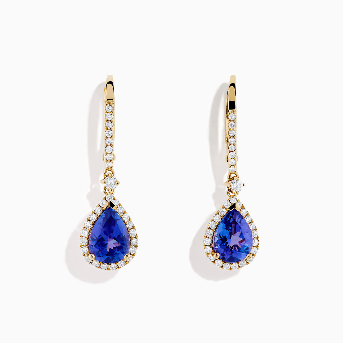 The Nahla 14K Yellow Gold Tanzanite and Diamond Dangle Halo Earrings showcase teardrop tanzanites encircled by diamonds, with extra diamonds on the hooks, all set against a white background.