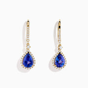 The Nahla 14K Yellow Gold Tanzanite and Diamond Dangle Halo Earrings showcase teardrop tanzanites encircled by diamonds, with extra diamonds on the hooks, all set against a white background.