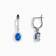 Introducing the 14K White Gold Oval Blue Sapphire and Diamond Drop Earrings, featuring striking oval blue sapphires surrounded by sparkling diamonds in a vertical drop design, set in elegant 14K white gold with diamond-accented hooks.
