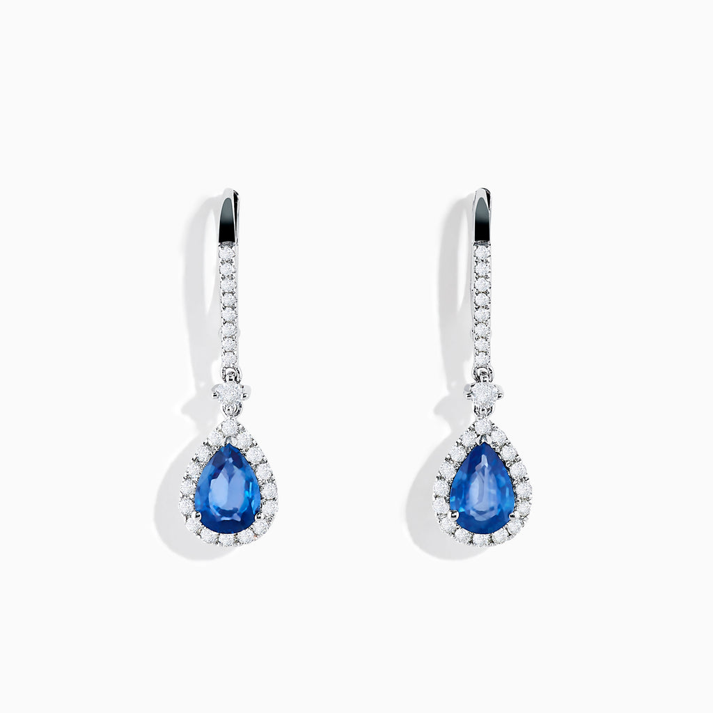 The 14K White Gold Pear Shape Blue Sapphire and Diamond Drop Earrings feature teardrop-shaped sapphires surrounded by white diamonds, set in elegant white gold, shown on a white background.