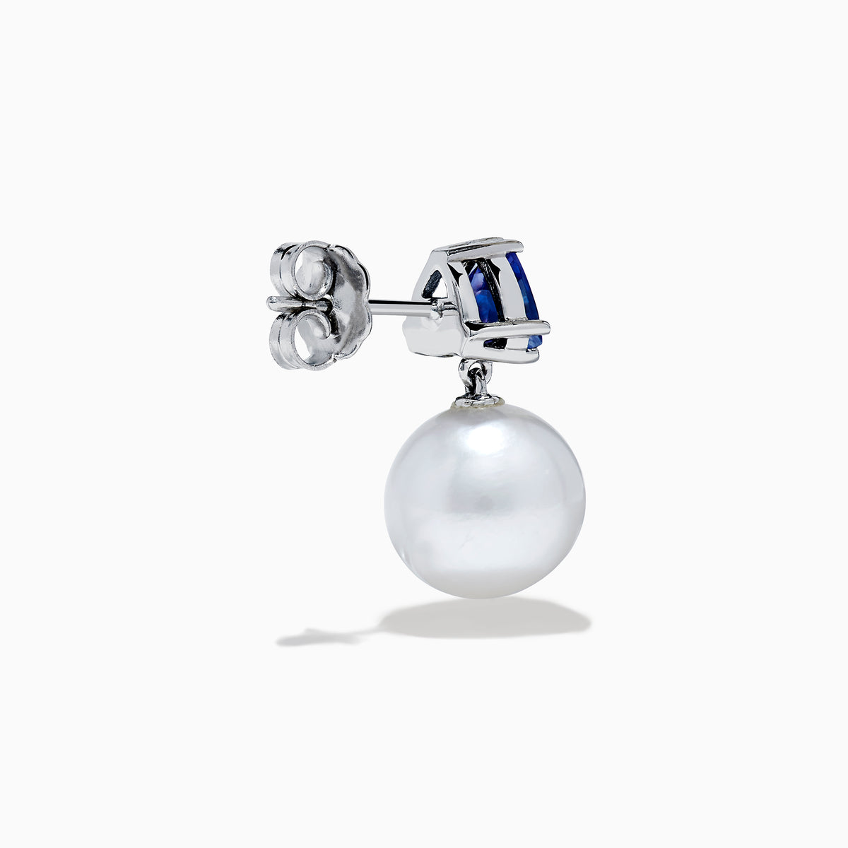 The Nahla 14K White Gold Fresh Water Pearl and Tanzanite Earrings feature round white pearls suspended below triangular blue tanzanite gemstones, set in white gold, displayed on a white background.